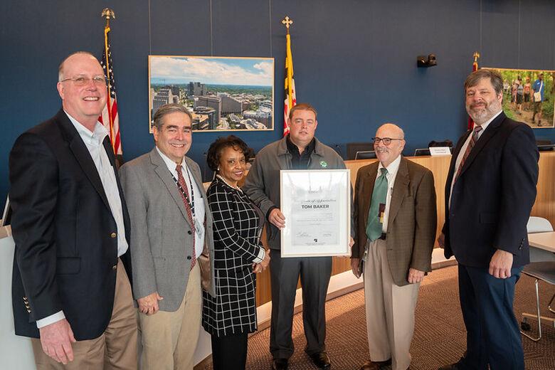 Montgomery Parks park manager Tom Baker holds the certificate that honors him for his help with the plane crash. Others in the photo are Director of Parks Mike Riley, Interim Planning Board Commissioners Robert Pinero and Cherri Branson, Interim Planning Board Chair Jeffrey Zyontz and Interim Planning Board Commissioner David Hill. (Courtesy Maryland-National Capital Park and Planning Commission)
